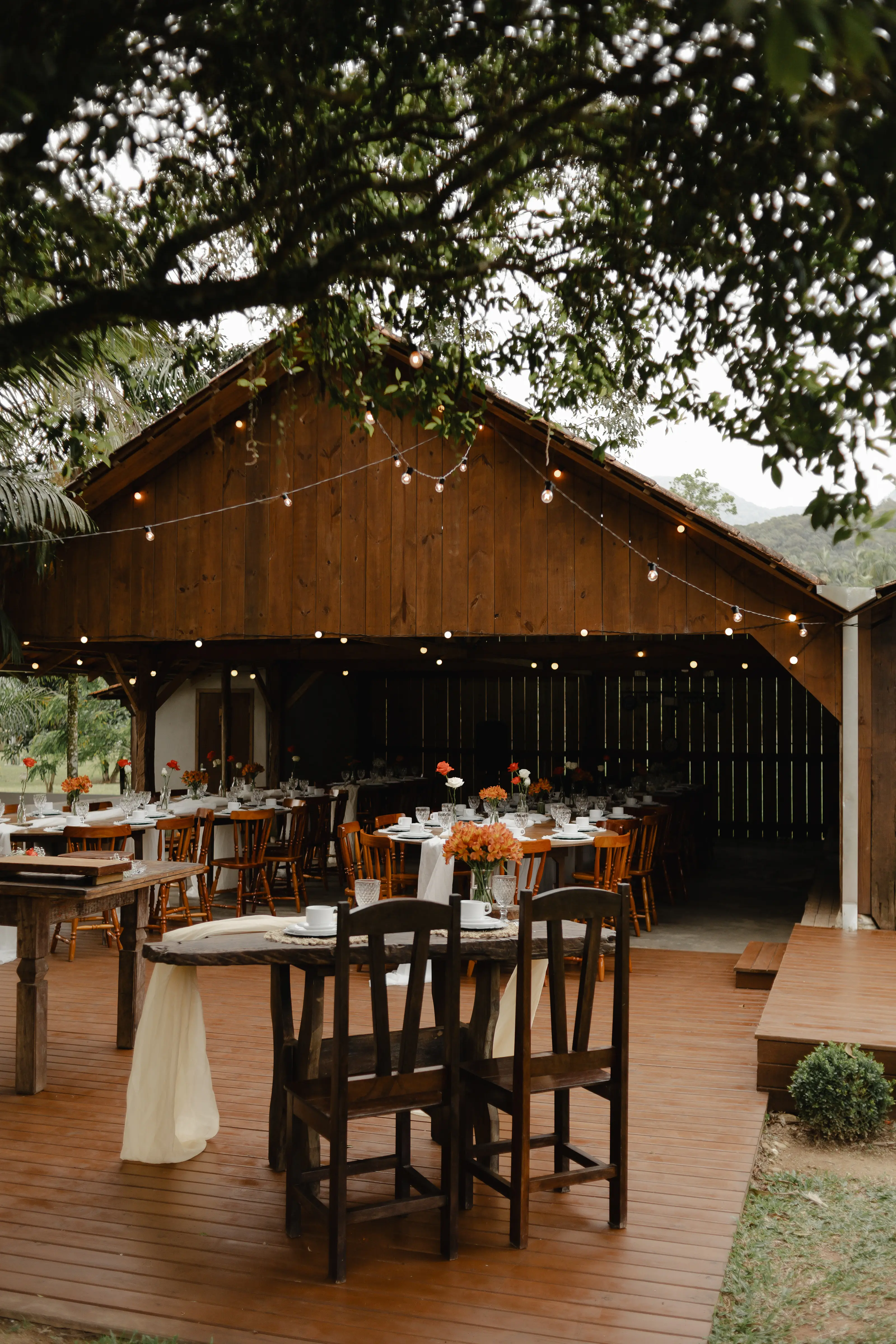 Mesa rústica com flores frescas e detalhes em dourado no Sítio Tambaú