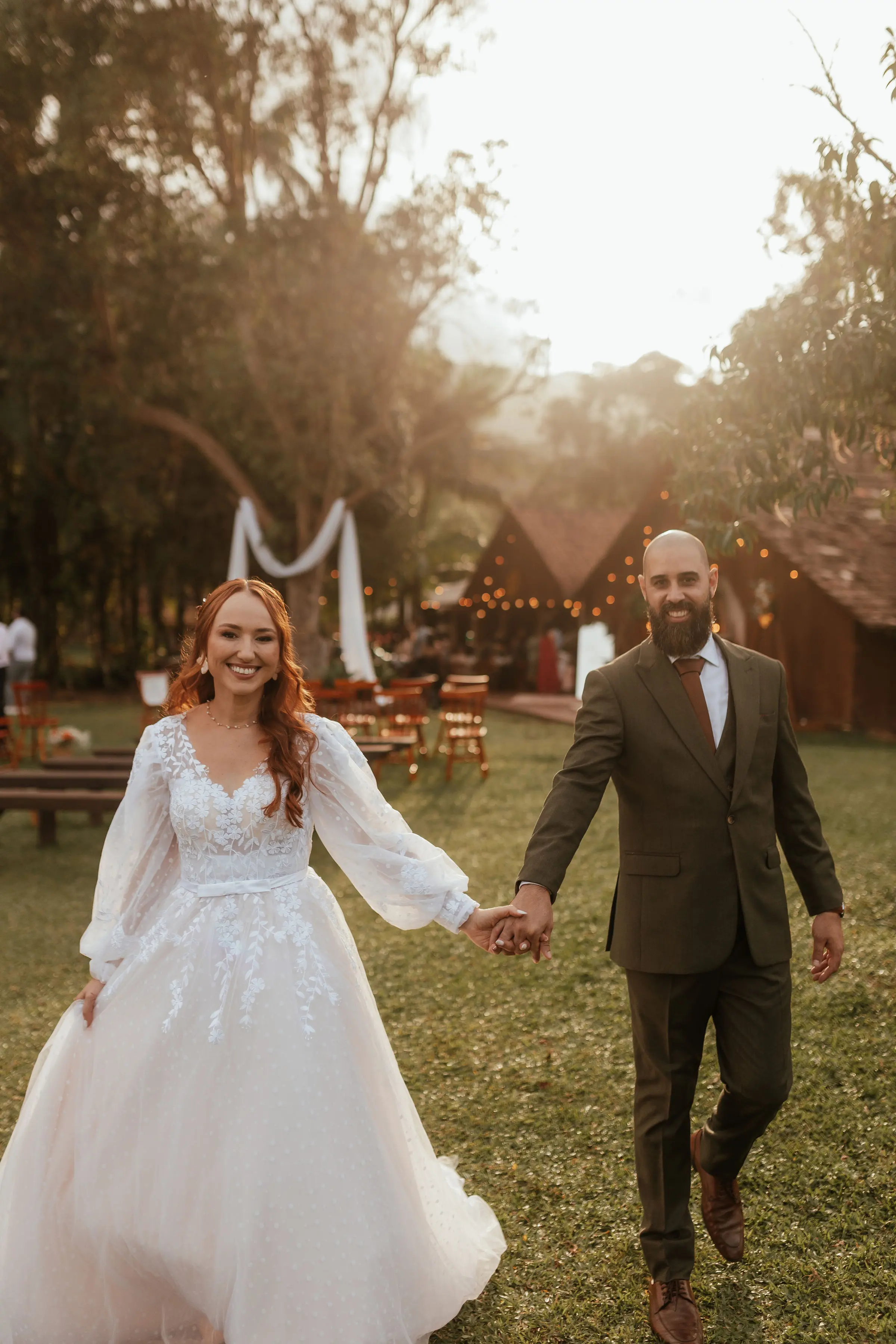 Noiva caminhando entre as árvores do Sítio Tambaú com luz dourada do entardecer